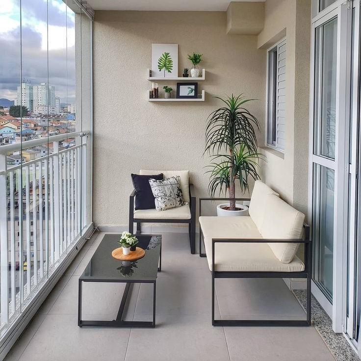 Balcony Design with Sleek Black Metal Furniture, Neutral Tones, and Greenery for a Relaxing Outdoor Retreat